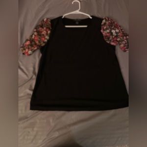 Size large black top with floral sleeves.